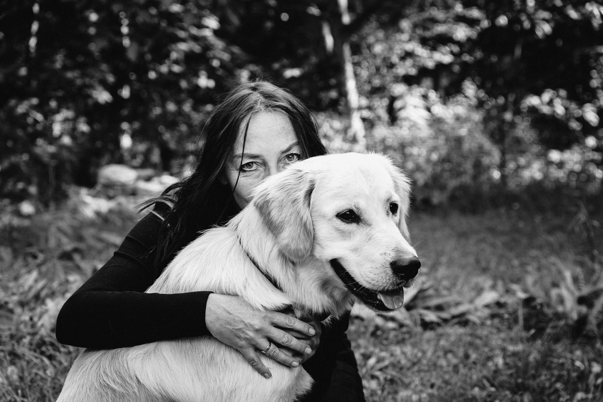 Frau umarmt von hinten einen großen Hund