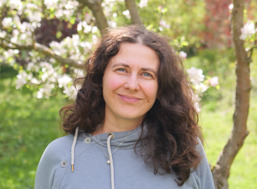 Autorin Marlene Hofmann vor blühenden Obstbäumen
